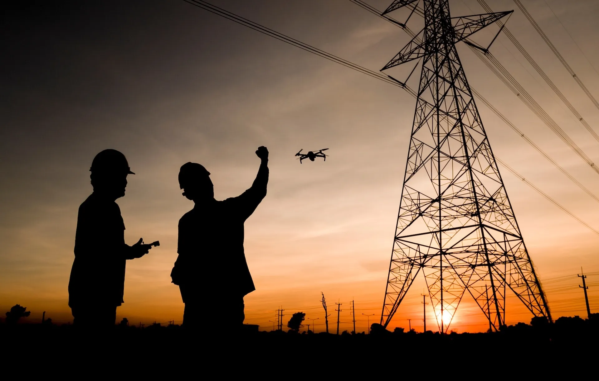Drone operator controlling UAV near power line infrastructure
