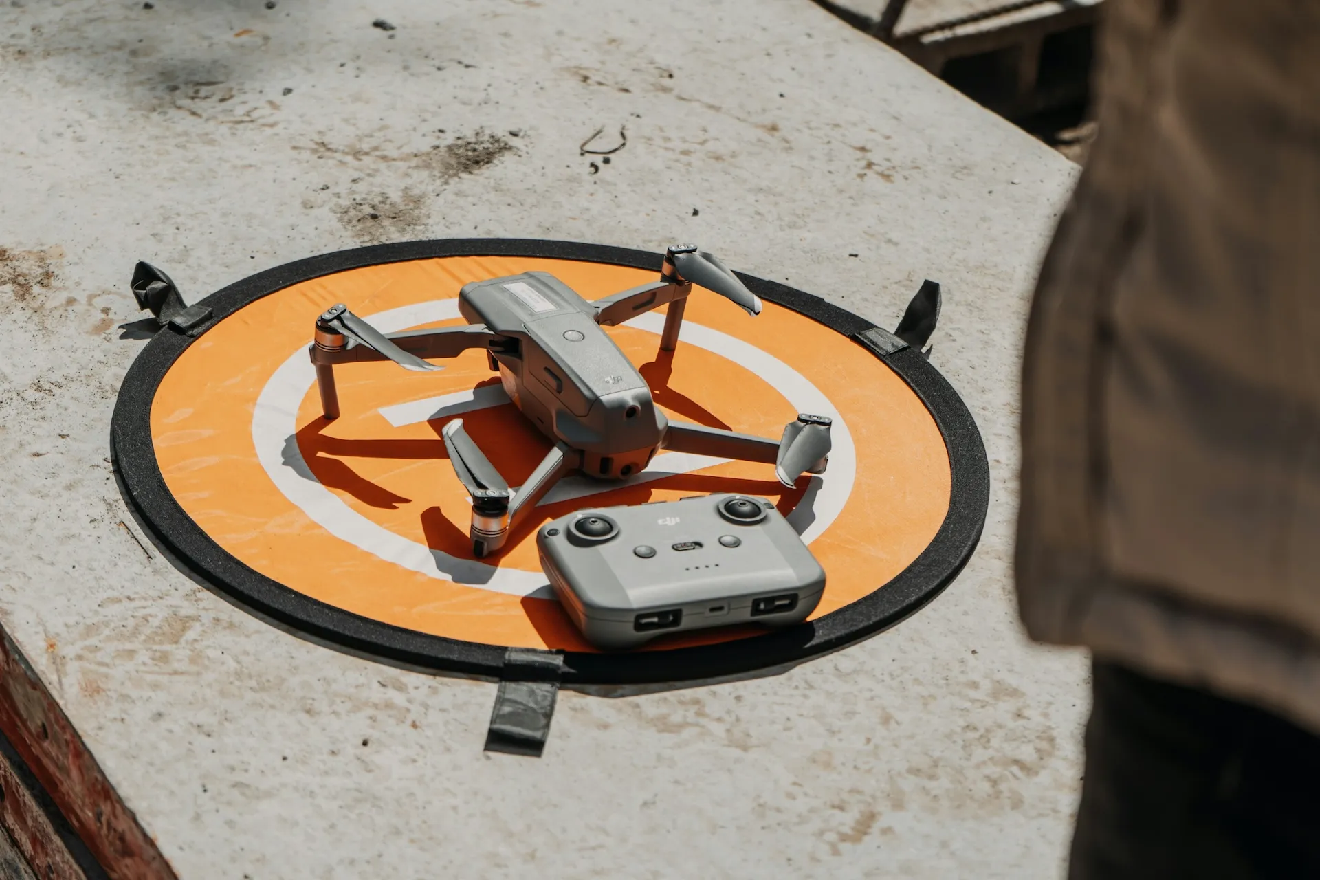 Drone pilot operating UAV for utility powerline inspection in open field