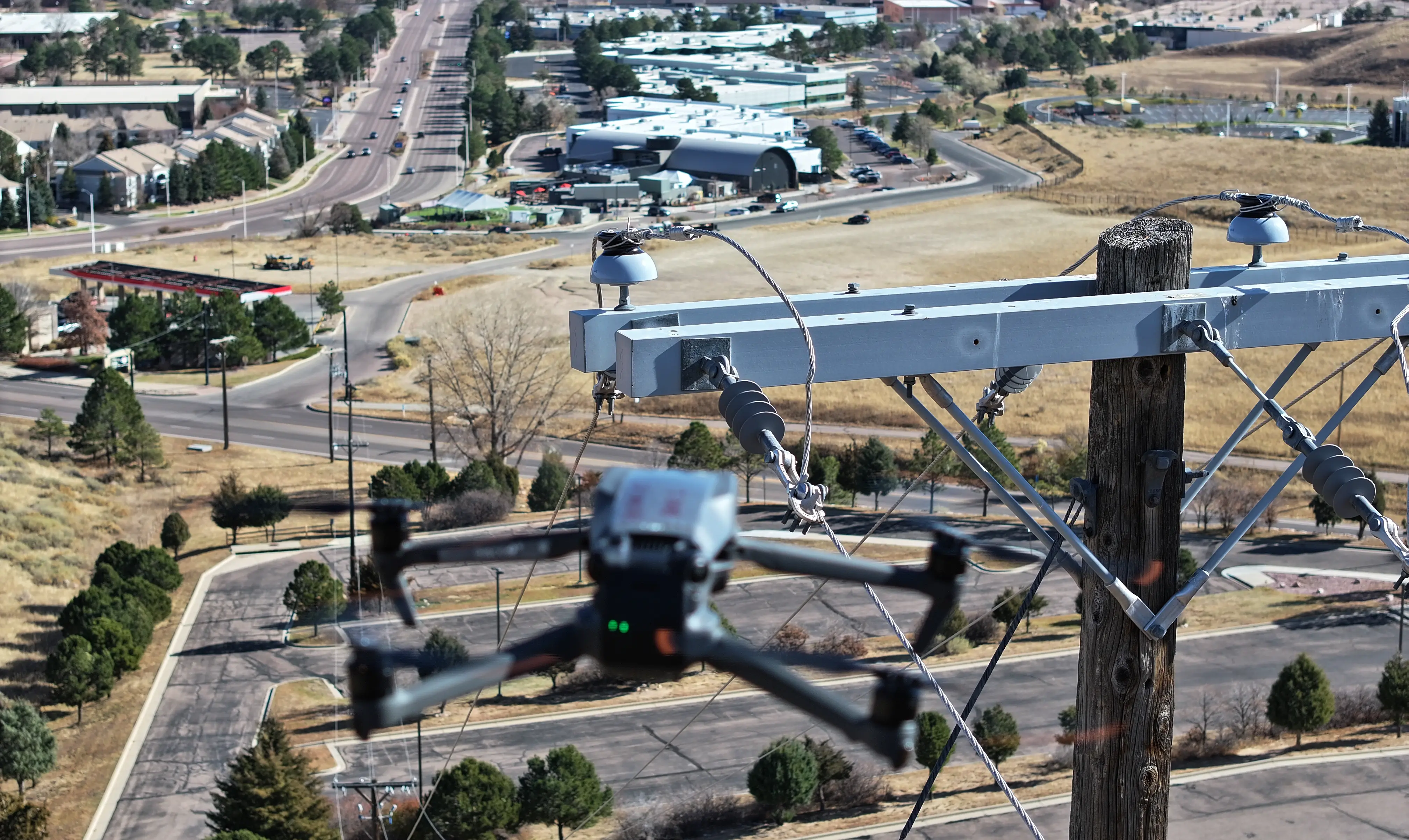Close-up of inspection drone hovering near utility pole in urban area